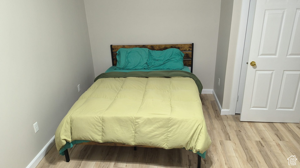 Bedroom with light wood finished floors and baseboards