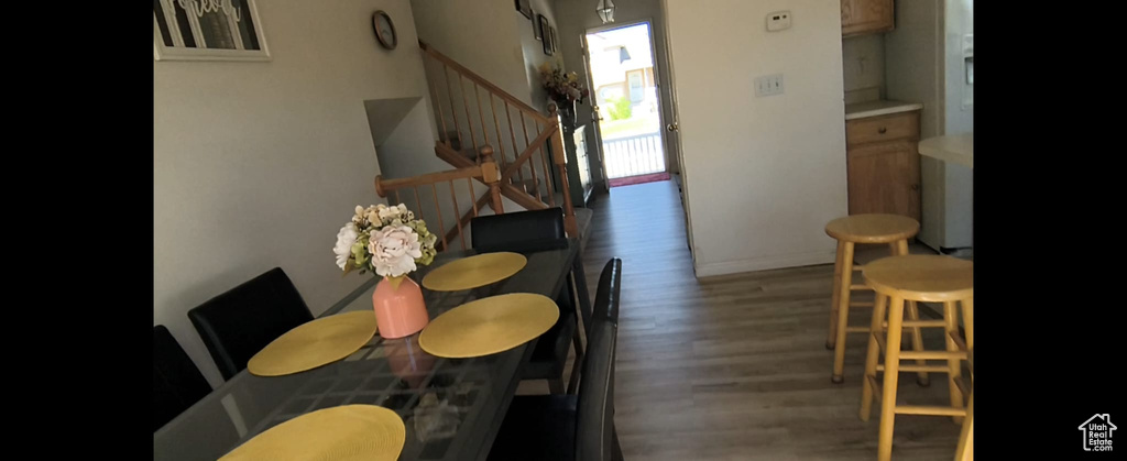 Dining space with wood finished floors, stairs, and baseboards
