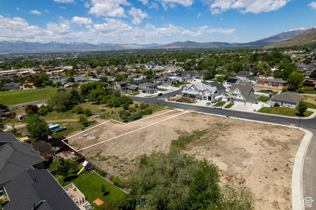 Aerial view of residential area featuring a mountainous background and property boundaries highlighted