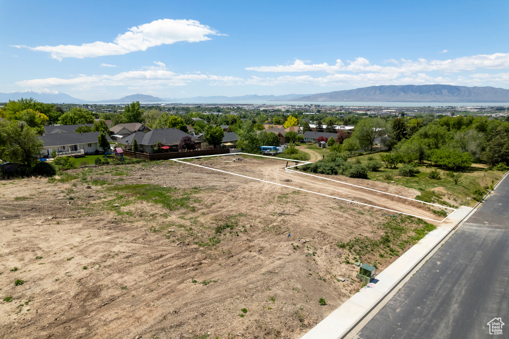 Aerial view of property and surrounding area with a mountainous background and property parcel outlined