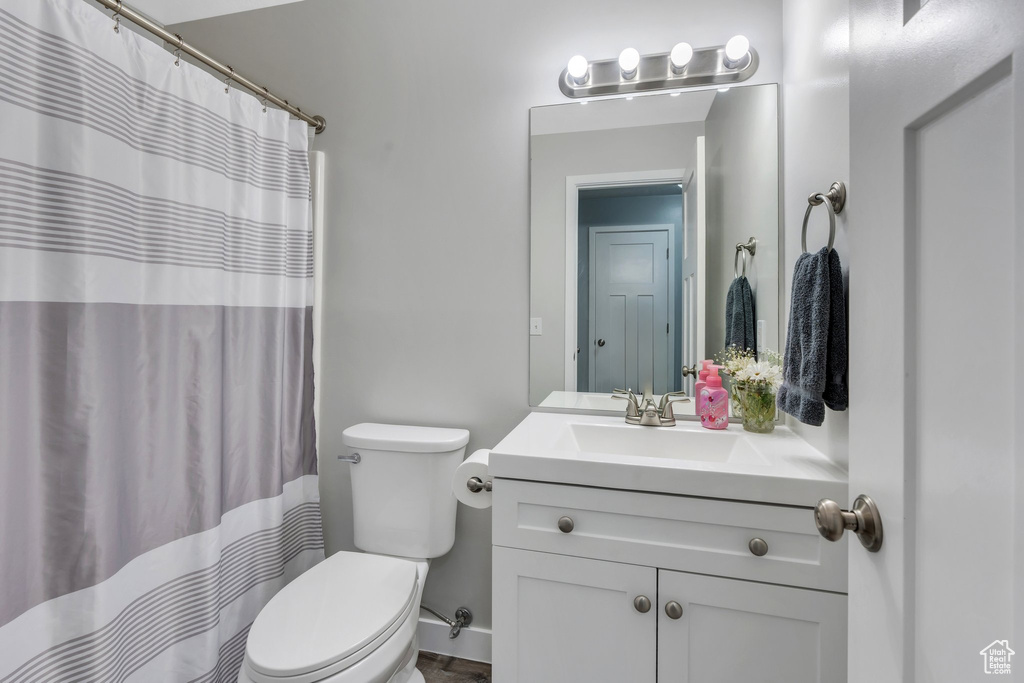 Full bathroom with vanity, toilet, and a shower with shower curtain