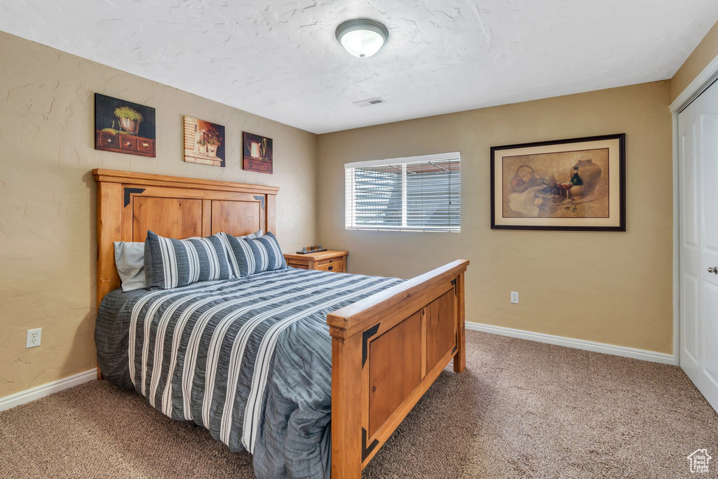 Bedroom featuring carpet floors and baseboards