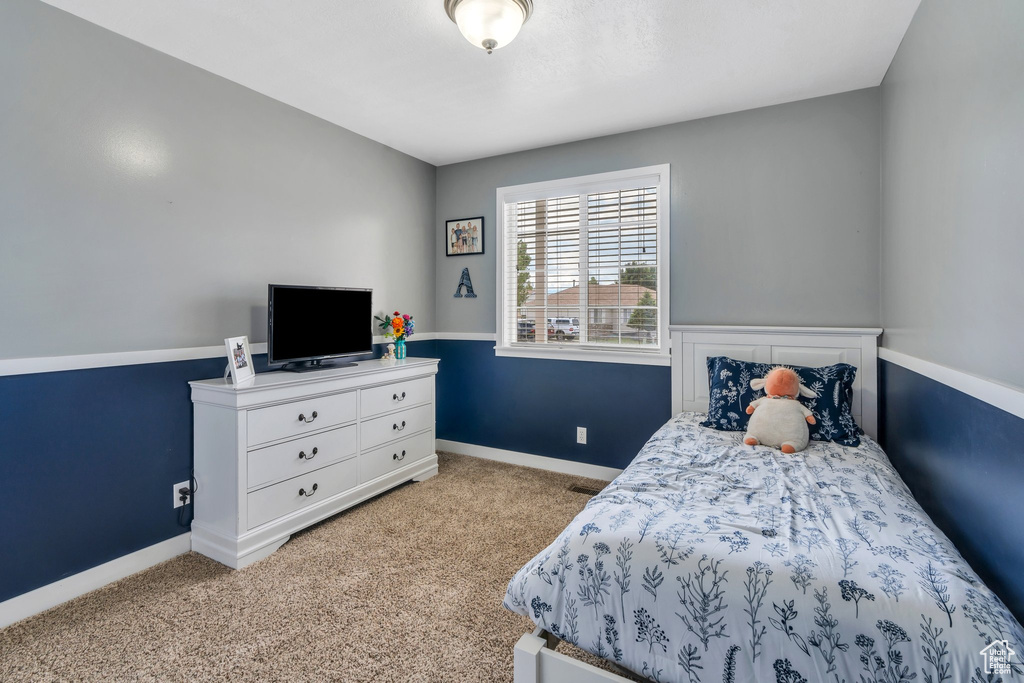 Bedroom featuring light carpet and baseboards