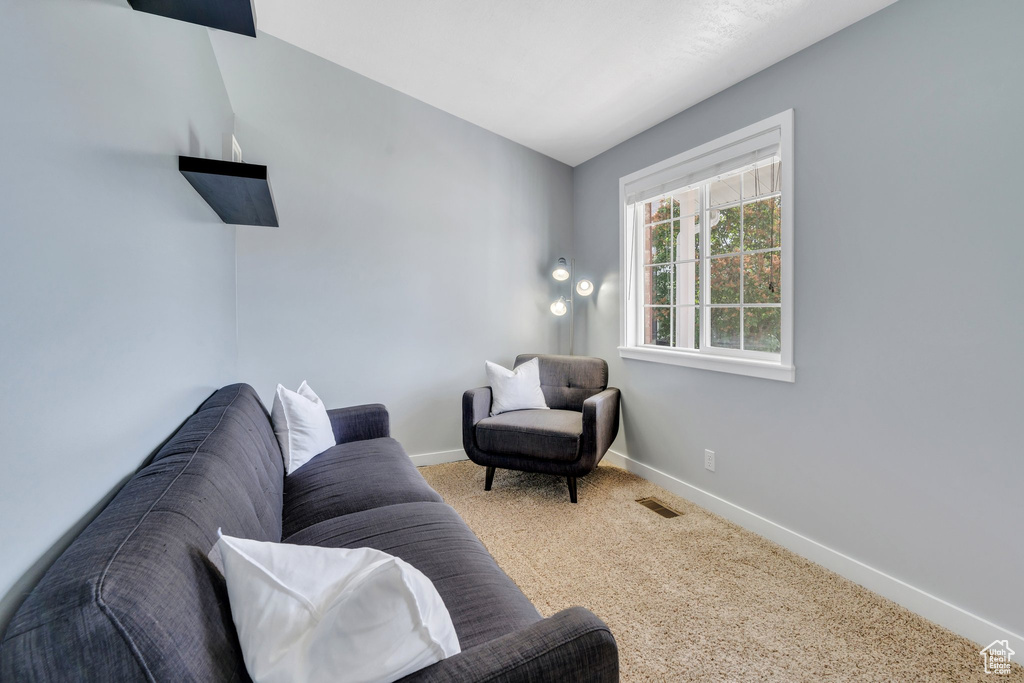 Carpeted living area featuring baseboards