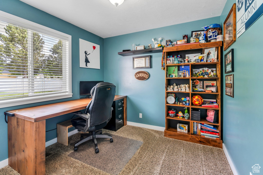 Carpeted office space with baseboards