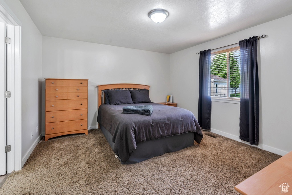 Bedroom featuring carpet and baseboards