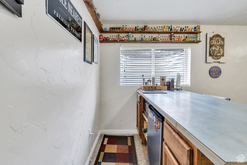 Indoor dry bar with dishwasher and baseboards