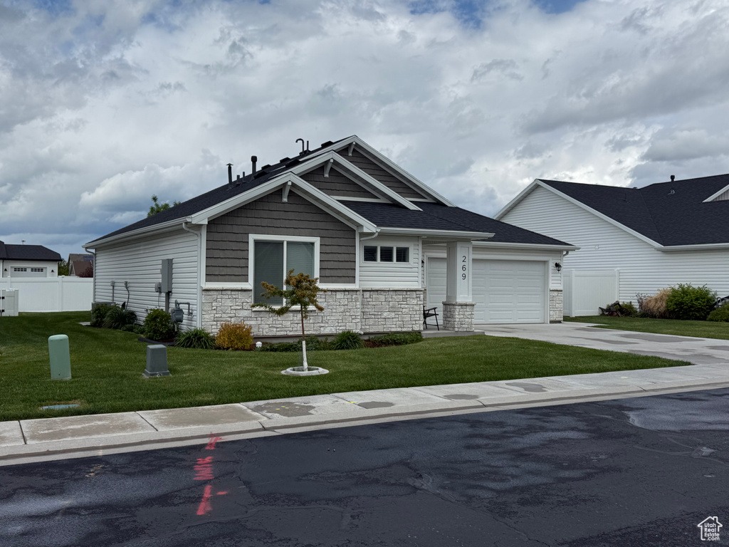 Craftsman inspired home featuring concrete driveway, stone siding, and a garage