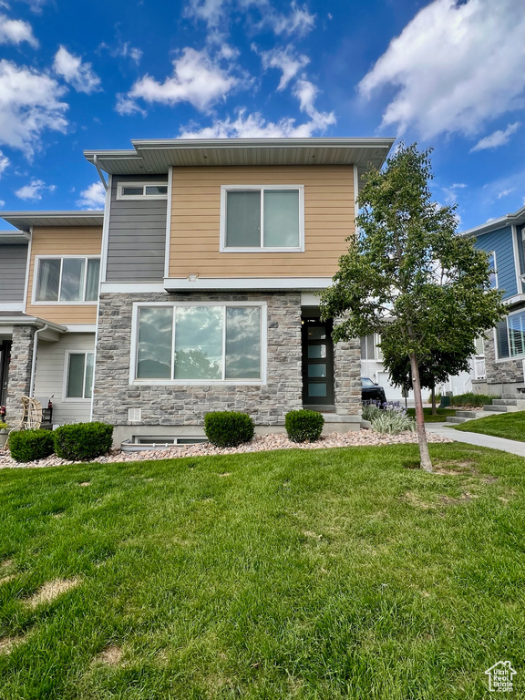 Contemporary house with stone siding and a front yard