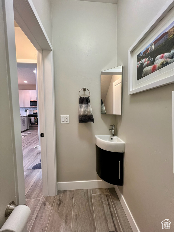 Bathroom with wood finished floors, baseboards, and vanity