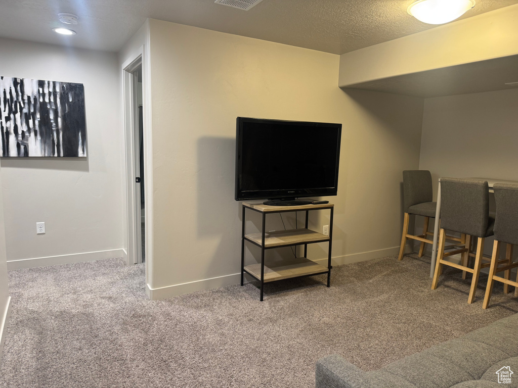Carpeted living area featuring baseboards
