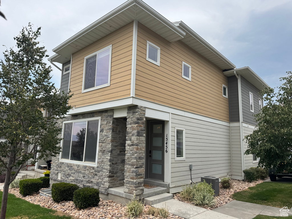 View of side of home featuring stone siding and a central AC unit