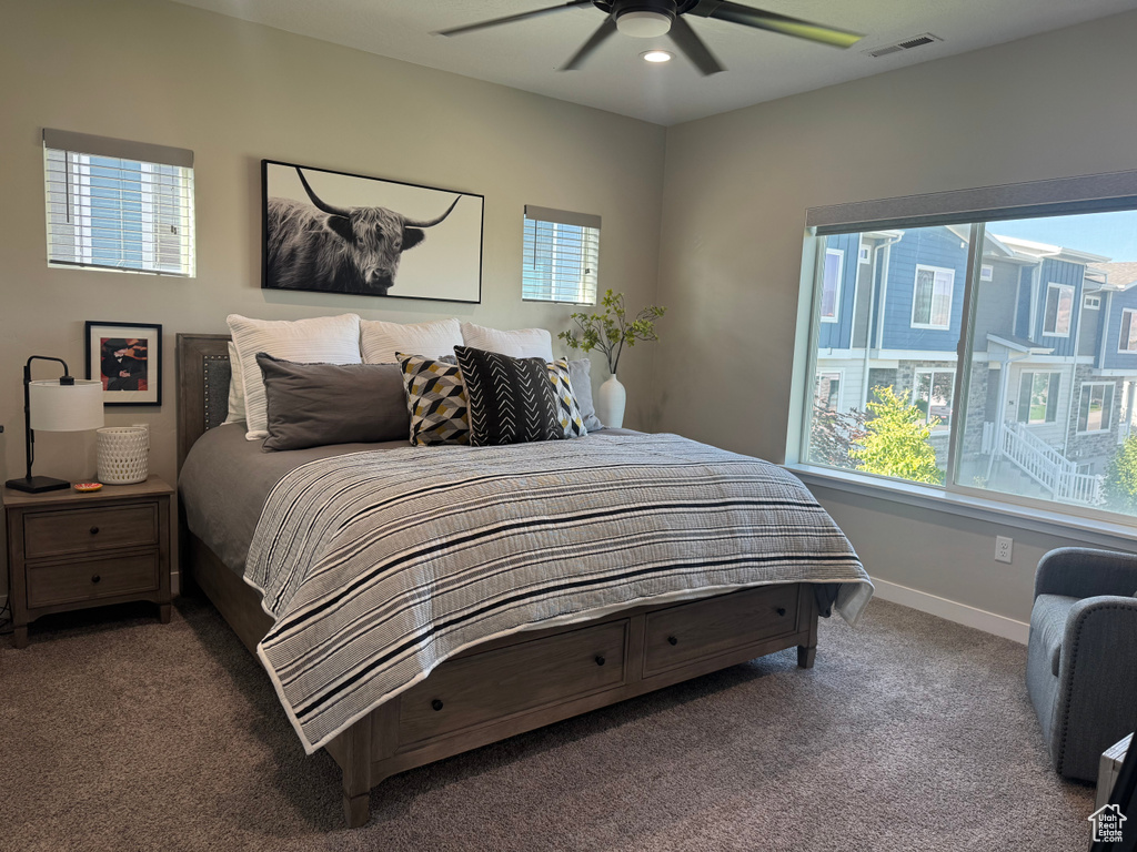 Carpeted bedroom featuring baseboards and ceiling fan