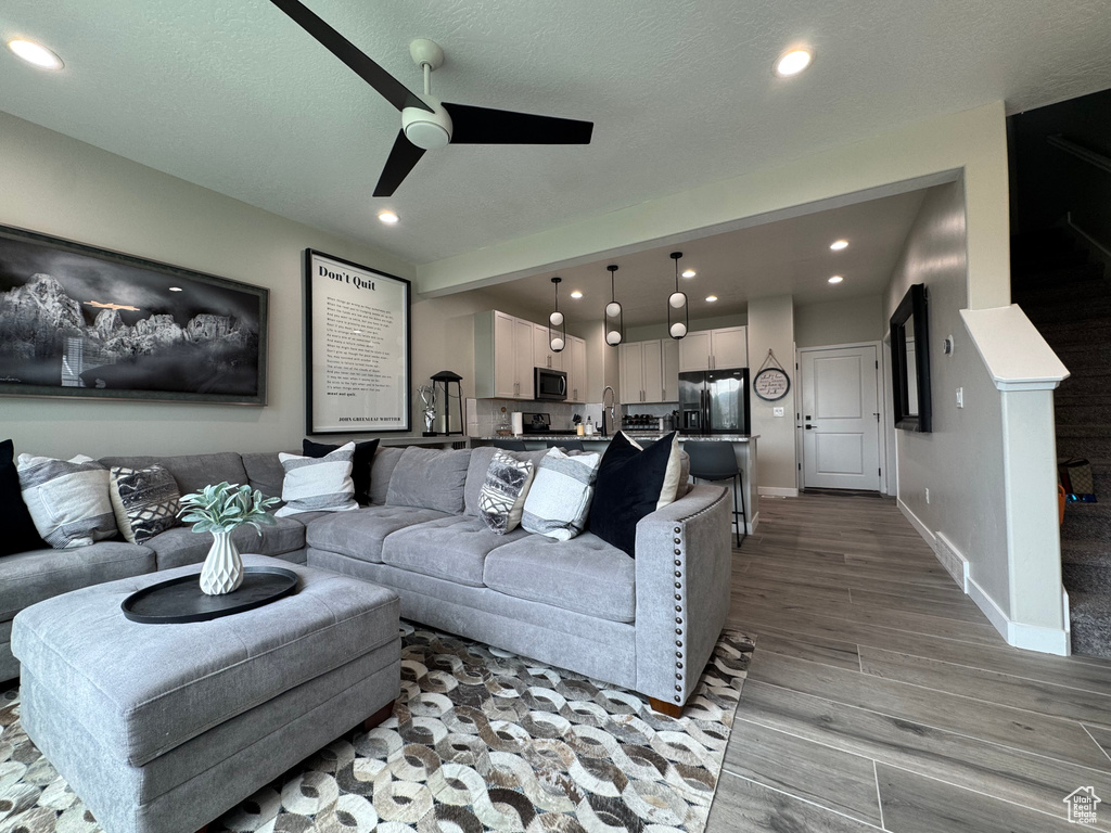Living room featuring ceiling fan, light wood finished floors, and recessed lighting
