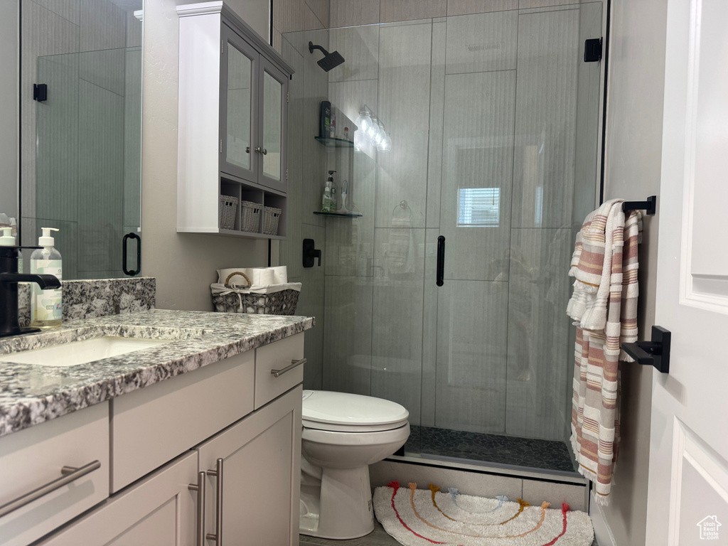 Full bathroom featuring vanity, a shower stall, and toilet