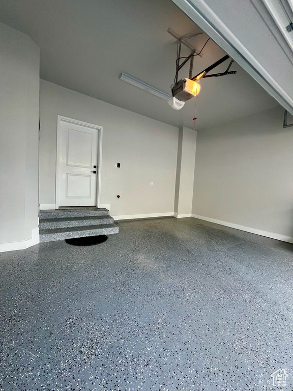 Garage with baseboards and a garage door opener
