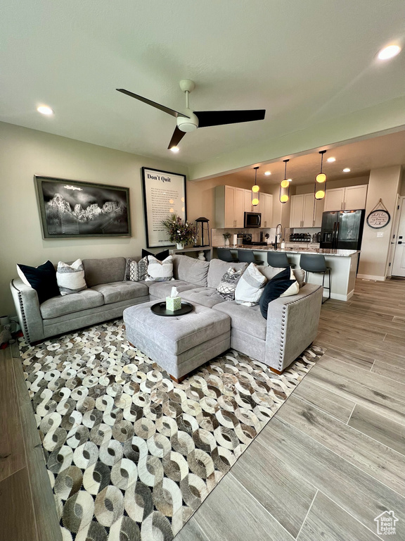 Living area with recessed lighting, light wood-style flooring, and a ceiling fan