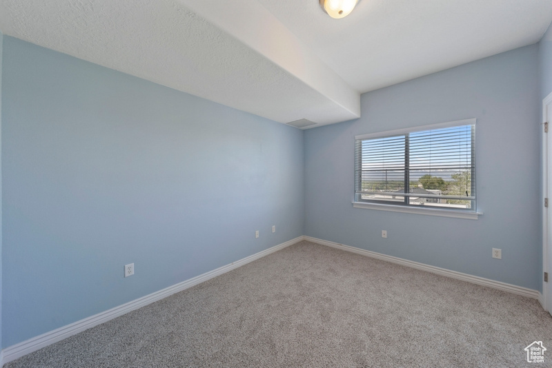 Carpeted empty room featuring baseboards