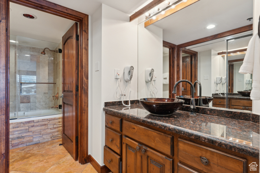 Bathroom with vanity, tiled shower / bath combo, tile patterned flooring, and recessed lighting