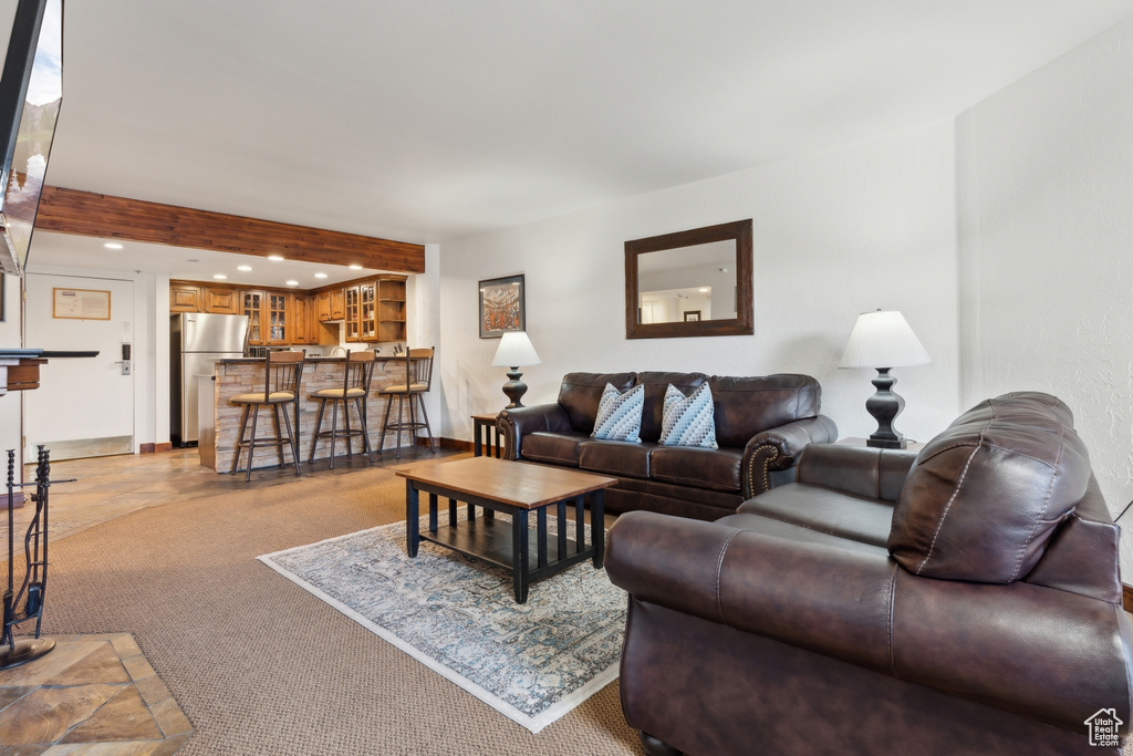 Living room featuring recessed lighting, light colored carpet, bar, and baseboards