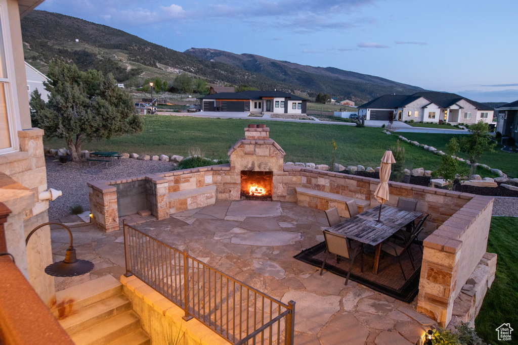 View of patio / terrace featuring an outdoor stone fireplace and a mountain view