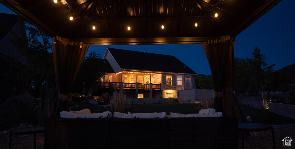 Back of house at night featuring an outdoor hangout area