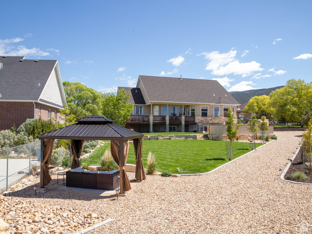 Back of house with a gazebo, an outdoor hangout area, and a patio