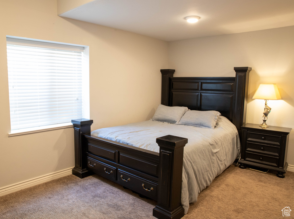 Bedroom with light colored carpet and baseboards