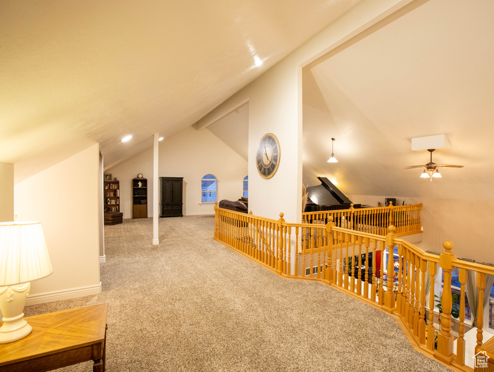 Additional living space with vaulted ceiling, carpet, and ceiling fan