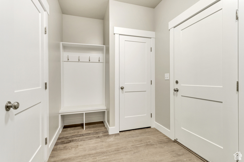 Mudroom with light wood finished floors and baseboards