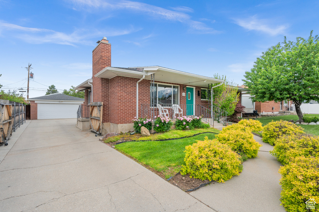 Ranch-style house with brick siding, a chimney, an outdoor structure, and a detached garage