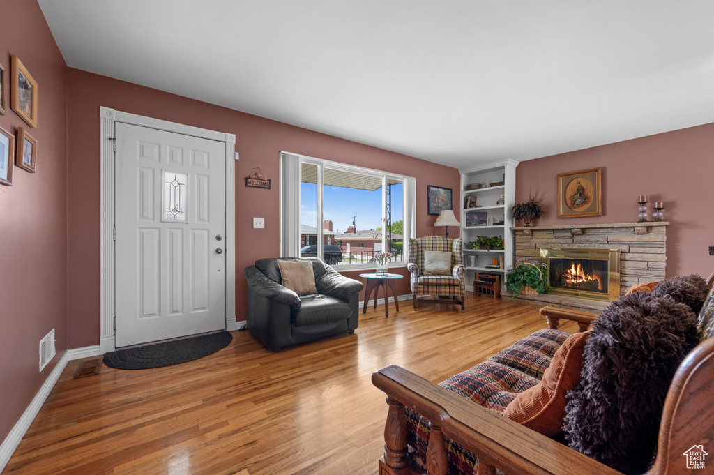 Living room featuring light wood finished floors, a fireplace, and baseboards