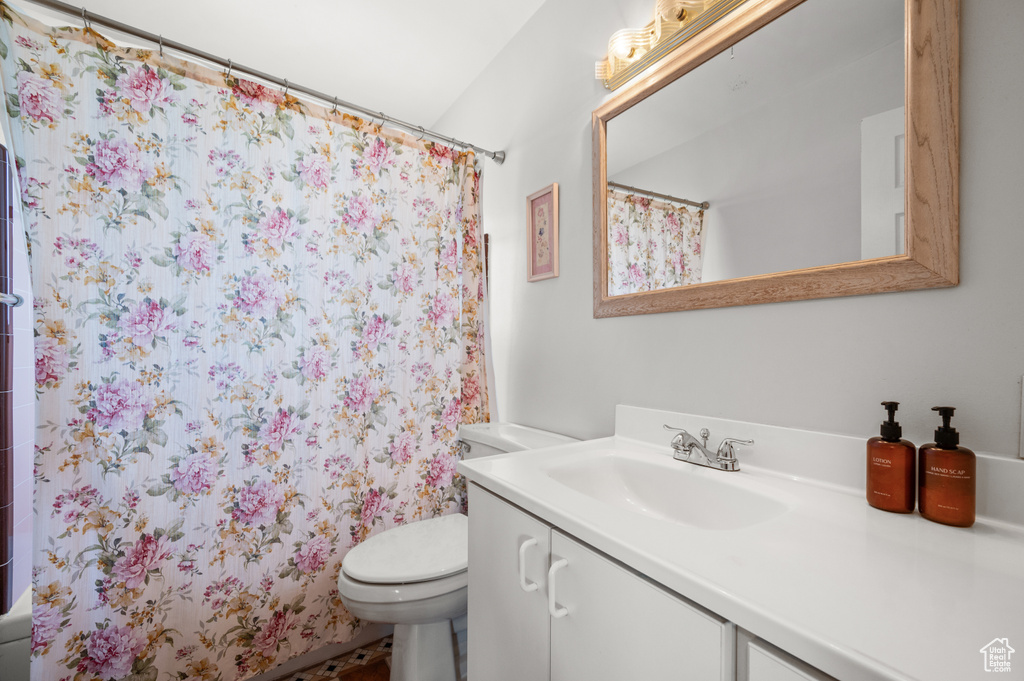 Bathroom with toilet, a shower with curtain, and vanity