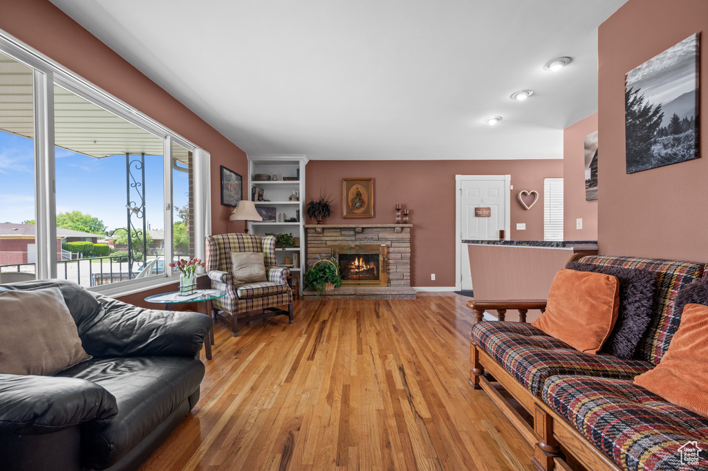 Living room with light wood finished floors, a fireplace, and baseboards