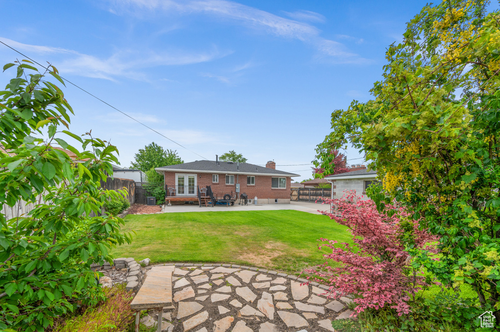Back of house with brick siding, a patio area, and french doors