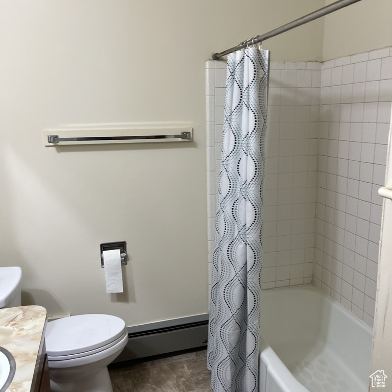 Full bath with a baseboard radiator, vanity, and shower / bath combo