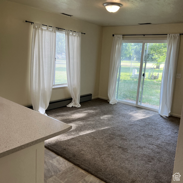 Unfurnished room featuring plenty of natural light and light carpet
