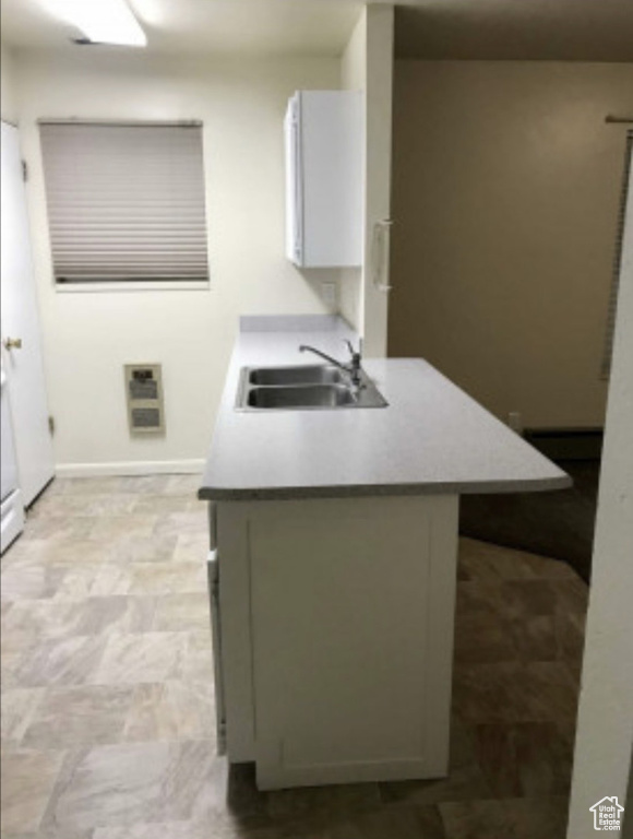 Kitchen featuring a sink and baseboards