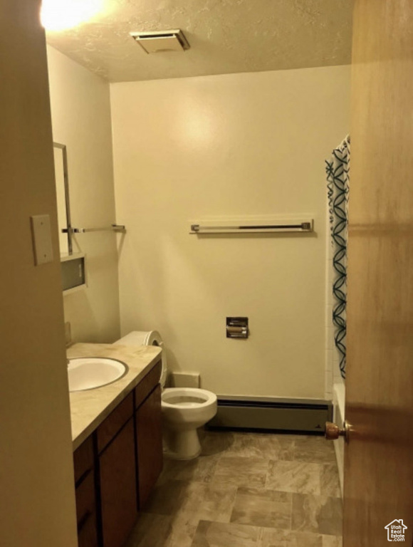 Full bath with a baseboard radiator, toilet, vanity, and shower / bathtub combination with curtain
