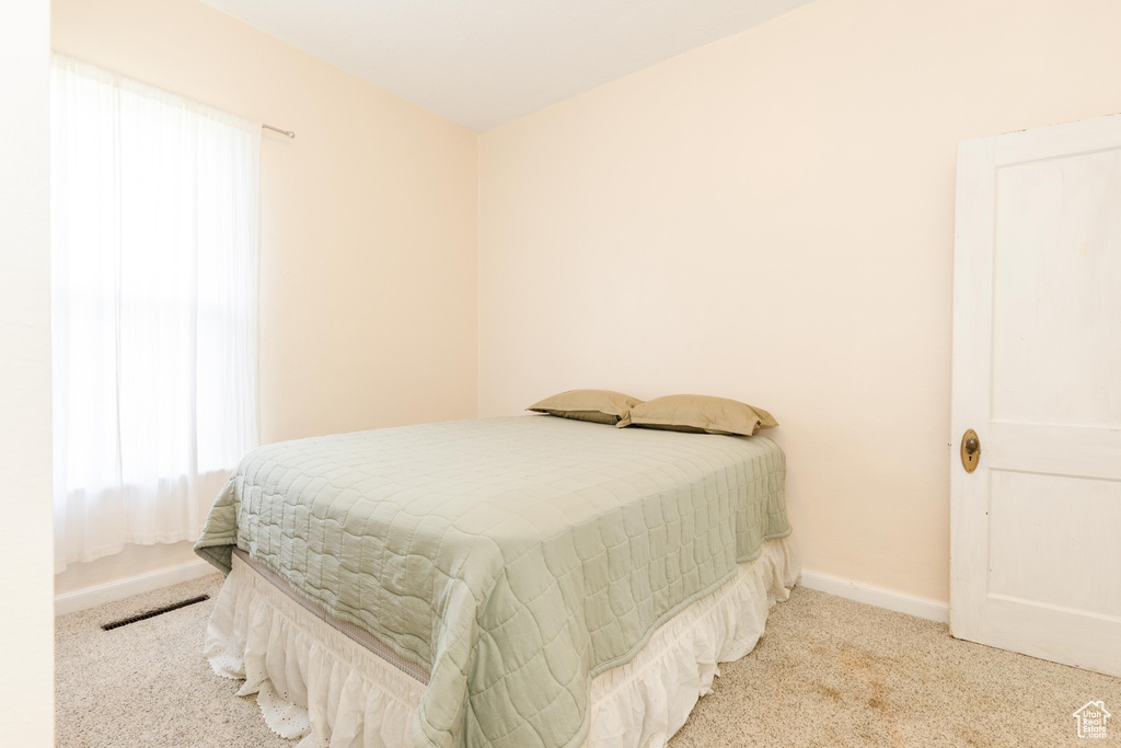 Bedroom with carpet floors, multiple windows, and baseboards