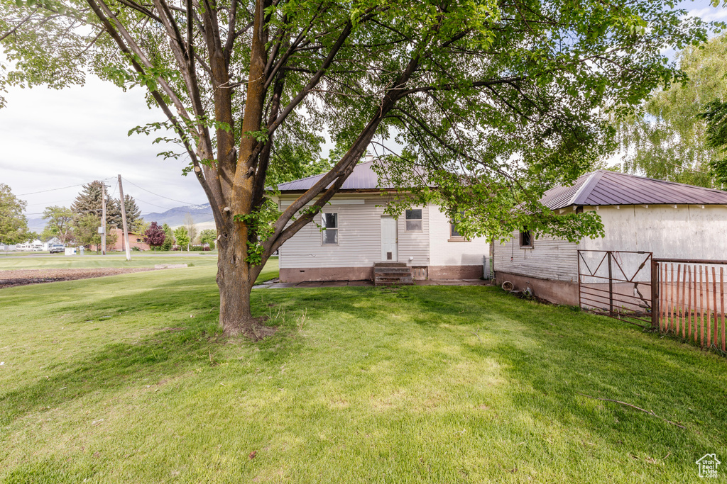 View of grassy yard with entry steps