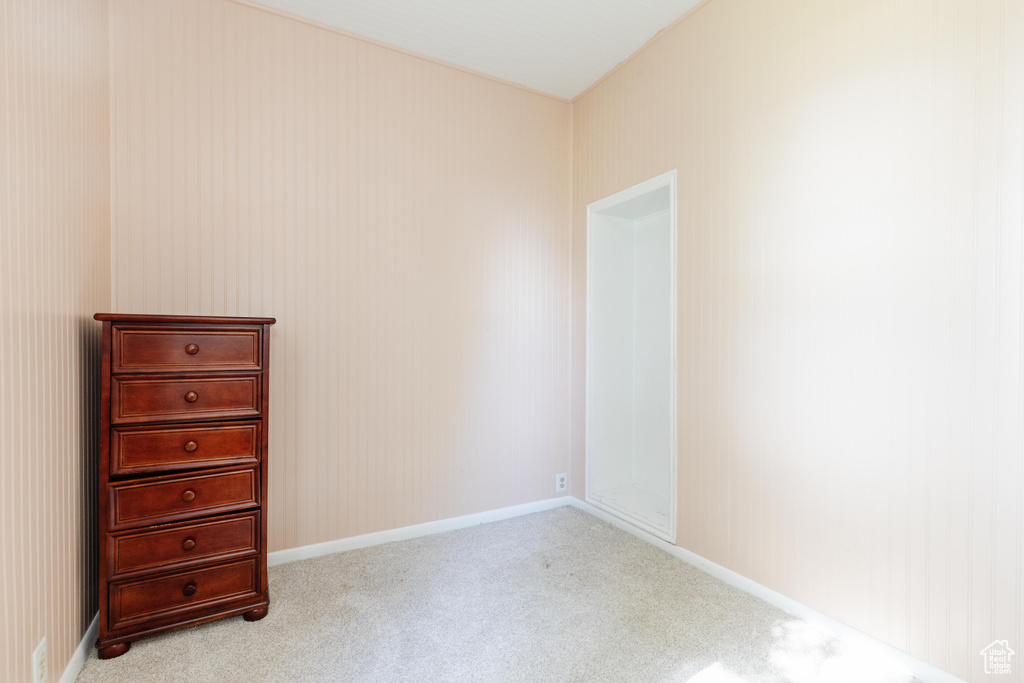 Bedroom with light colored carpet and baseboards