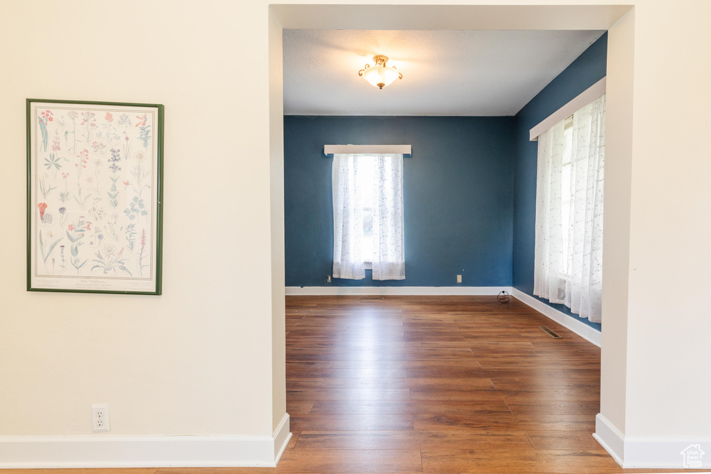 Unfurnished room featuring wood finished floors and baseboards