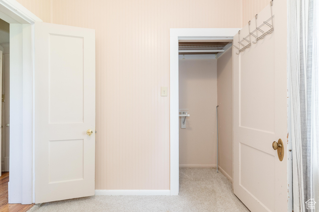 Hall with baseboards and light colored carpet