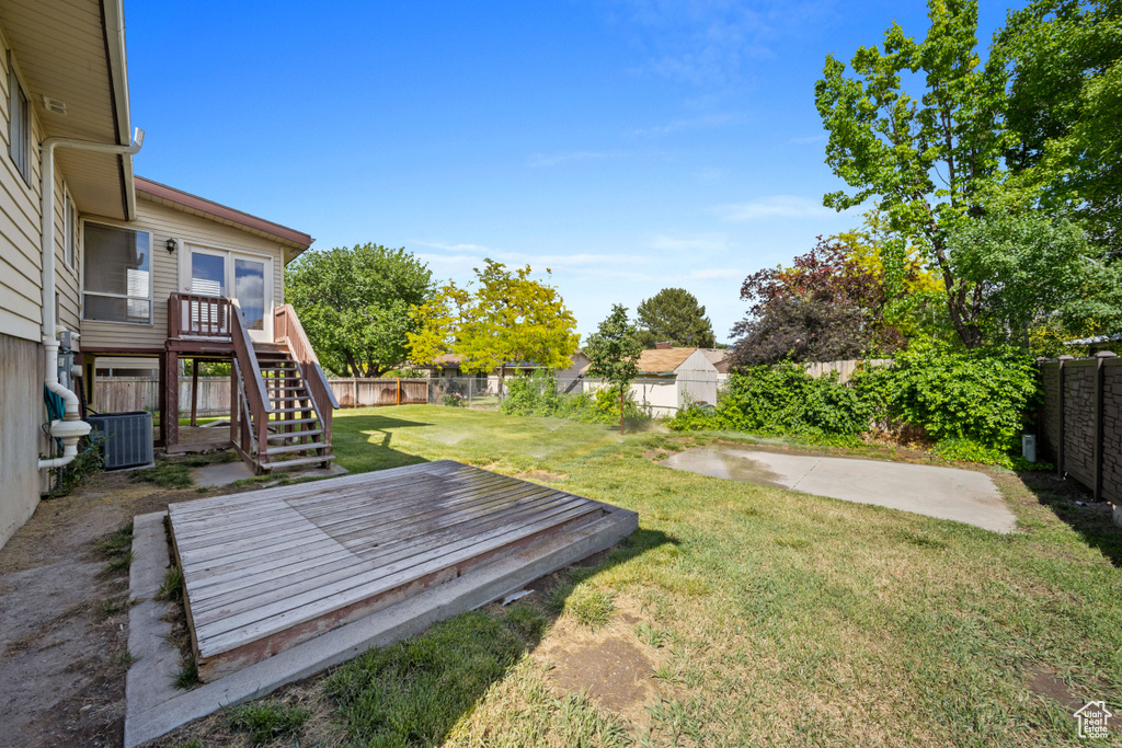 View of yard with a deck, stairs, and central air condition unit