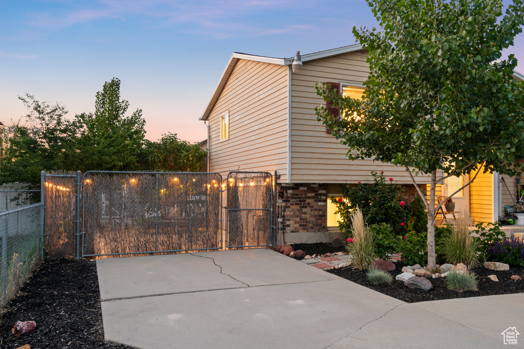 View of side of home featuring a gate and brick siding