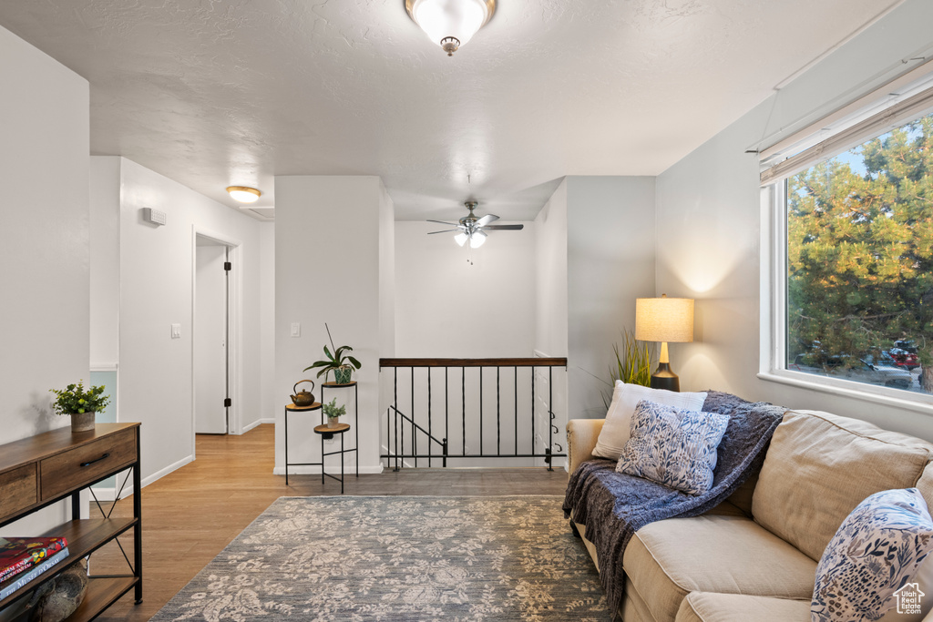 Living room with wood finished floors, baseboards, and ceiling fan