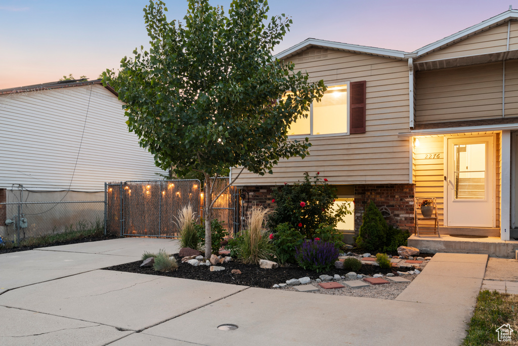 Property exterior at dusk featuring brick siding and driveway