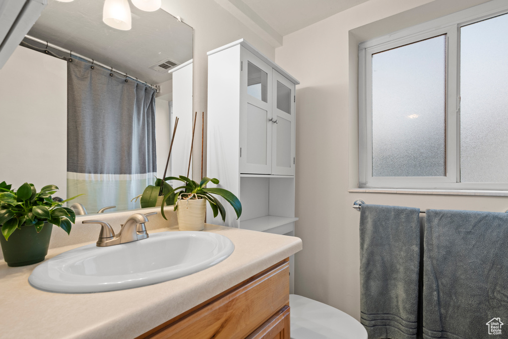 Bathroom with vanity, toilet, and a shower with shower curtain