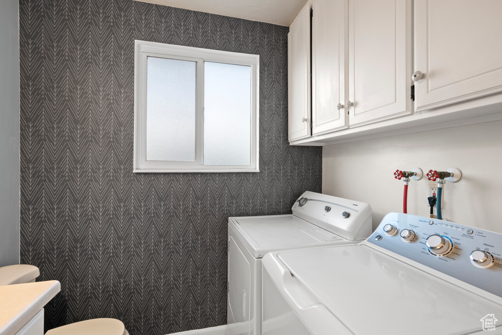 Laundry area featuring independent washer and dryer and wallpapered walls